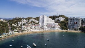 A coastal resort area with white buildings, a beach, and boats in the water. - Tesoro Manzanillo (Manzanillo)