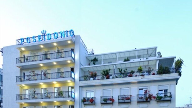 Un hôtel à plusieurs étages doté de balcons ornés de plantes et de fleurs.