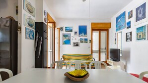 Un comedor con una mesa blanca, sillas y un centro de mesa decorativo.