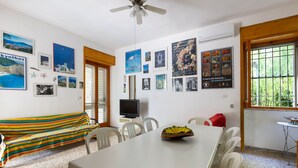 Un comedor con una mesa, sillas, un televisor y varias fotografías enmarcadas en las paredes.