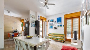 Un comedor con mesa y sillas, una cocina equipada y una sala de estar con sofá y televisor.