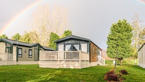 A row of mobile homes with a rainbow in the background. - Luxury Lodge in Stunning Surroundings (York)