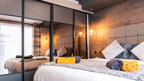 A modern hotel room with a large bed, a mirror, and a wooden headboard. - Luxury Lodge in Stunning Surroundings (York)