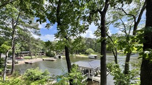 A lakeside property with docked boats, a covered boat house, and a gazebo. - Camelot on Lake Hamilton | Dock, Hot Tub + Theater (Hot Springs)