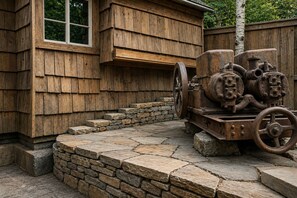 A rustic wooden building with a stone staircase leading to a porch.
