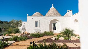 A white building with a stone roof, a door, and a window.