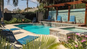 A swimming pool with lounge chairs and a pergola.