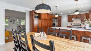 Une cuisine moderne avec des meubles en bois, un îlot central et des luminaires suspendus.