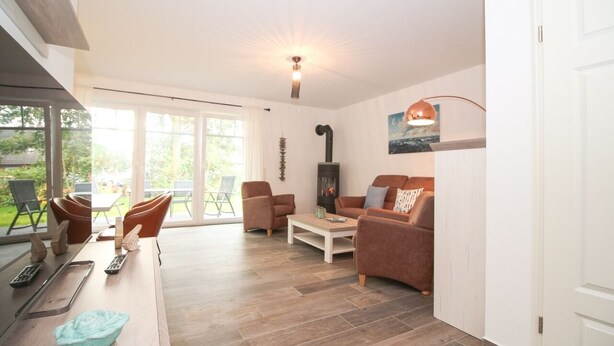 A modern living room with a fireplace, comfortable seating, and a dining area with a table and chairs.