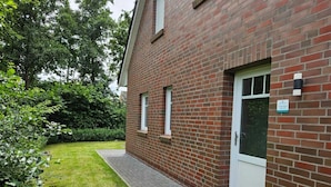 A brick building with a small garden and a paved pathway.