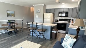 A compact living space with a kitchen, dining area, and a sofa. - 9A, Resting Beach Face (Destin)