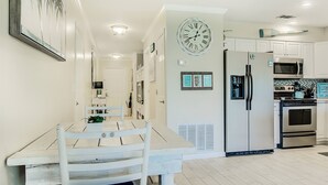 A modern kitchen with white cabinetry, a double-door refrigerator, a microwave, and a stove. - 7A, Sun Sand & Solitude (Destin)