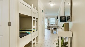 A narrow hallway with bunk beds on one side and a desk with a chair on the other. - 7A, Sun Sand & Solitude (Destin)