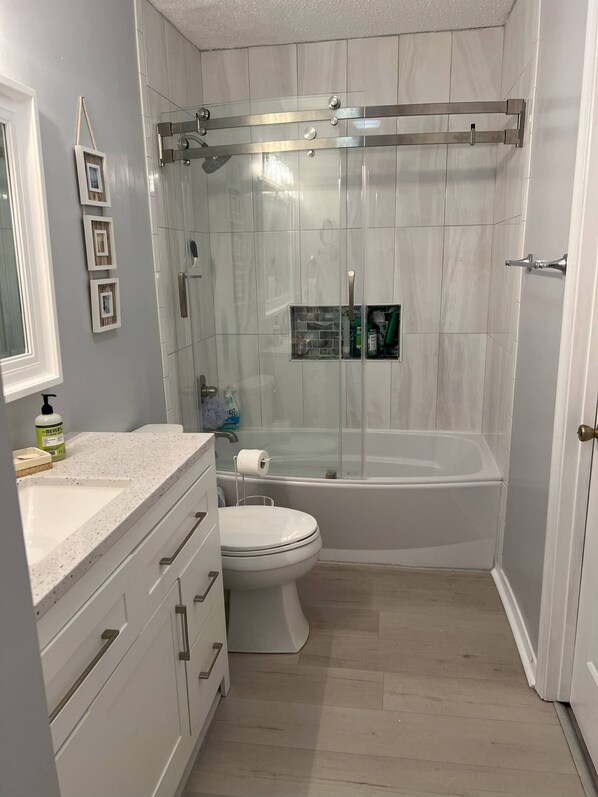 A modern bathroom with a glass-enclosed shower, a white toilet, and a vanity with drawers. - 8F, Isle Be Back (Destin)