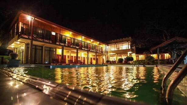A multi-story hotel with a swimming pool at night. - Taprospa Tissa (Weerawila)