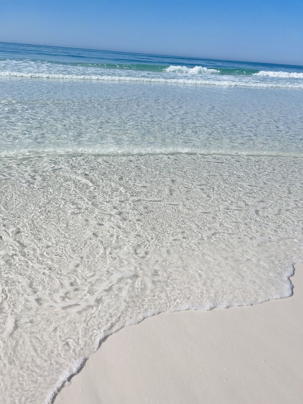 Una playa con agua cristalina y olas suaves.