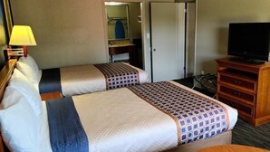 A hotel room with two beds, a television, a dresser, and a mirror. - Capt. John Smith Inn (Williamsburg)