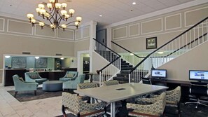 A lobby with a reception desk, seating area, staircase, and a chandelier. - Williamsburg Historic District (Williamsburg)