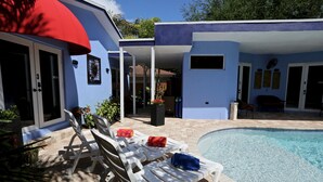 A poolside area with lounge chairs and a swimming pool. - Fantasy Island Inn - Poolside Queen Room 3 (Wilton Manors)