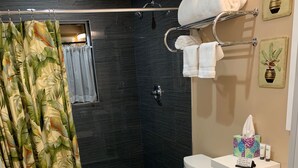 A modern bathroom with a shower, toilet, and sink. - Fantasy Island Inn - Poolside Queen Room 3 (Wilton Manors)