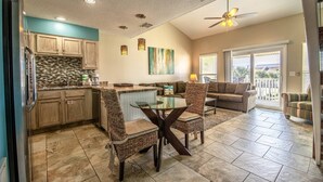 A spacious kitchen with a dining area, a ceiling fan, and a view to the outside. - 9G, Tan Lines & Good Times (Destin)