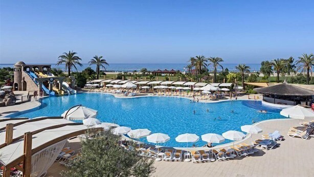 A large outdoor swimming pool with multiple water slides and sun loungers. - Club Felicia Village (Manavgat)
