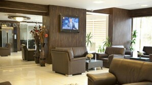 A modern lobby with leather sofas, a flat-screen TV, and a reception desk. - Grand Abimo Hotel (Istanbul)