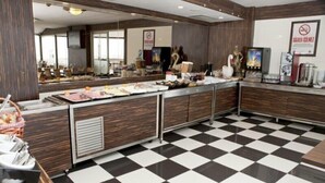 A buffet area with a checkered floor, stainless steel counters, and various food items displayed. - Grand Abimo Hotel (Istanbul)