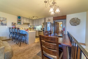 Enjoy cooking and dining in this well-equipped kitchen with a central island, refrigerator, oven, and ample counter space.