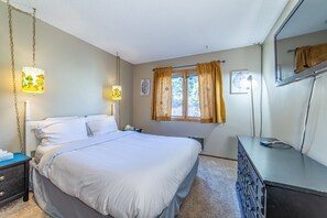 A bedroom with a bed, bedside tables, a dresser, a window with curtains, and wall-mounted lights. - 3 Bedroom Townhome with Views Near The Village at Mammoth! Wifi! (Mammoth Lakes)