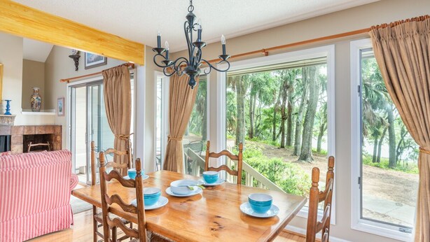 A dining area with a wooden table, chairs, and blue plates. - Bluff Villa 2014 on Dataw Island (Saint Helena Island)