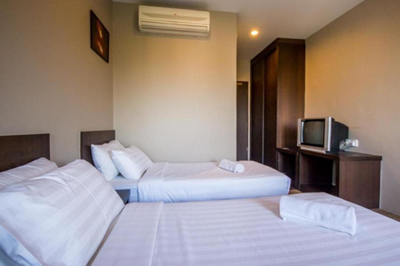 Una camera d'albergo con due letti, una televisione e un condizionatore.