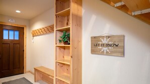 A wooden bench, a wooden shelf with a plant, and a sign that reads "LET IT SNOW". - Northstar - Ski Trail Condo (Truckee)