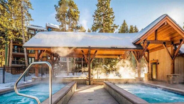 Un área de jacuzzi con terraza de madera y zona de estar cubierta.