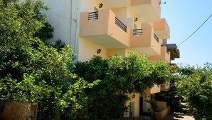 A multi-story residential building with balconies, surrounded by lush greenery. - Argyro Apartments (Agios Nikolaos)