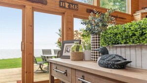 Ein Holzinterieur mit Meerblick, ein Tisch mit Stühlen und eine Theke mit Dekoration.