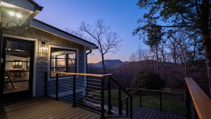 Une maison moderne dotée d’une terrasse en bois et offrant une vue sur les montagnes.