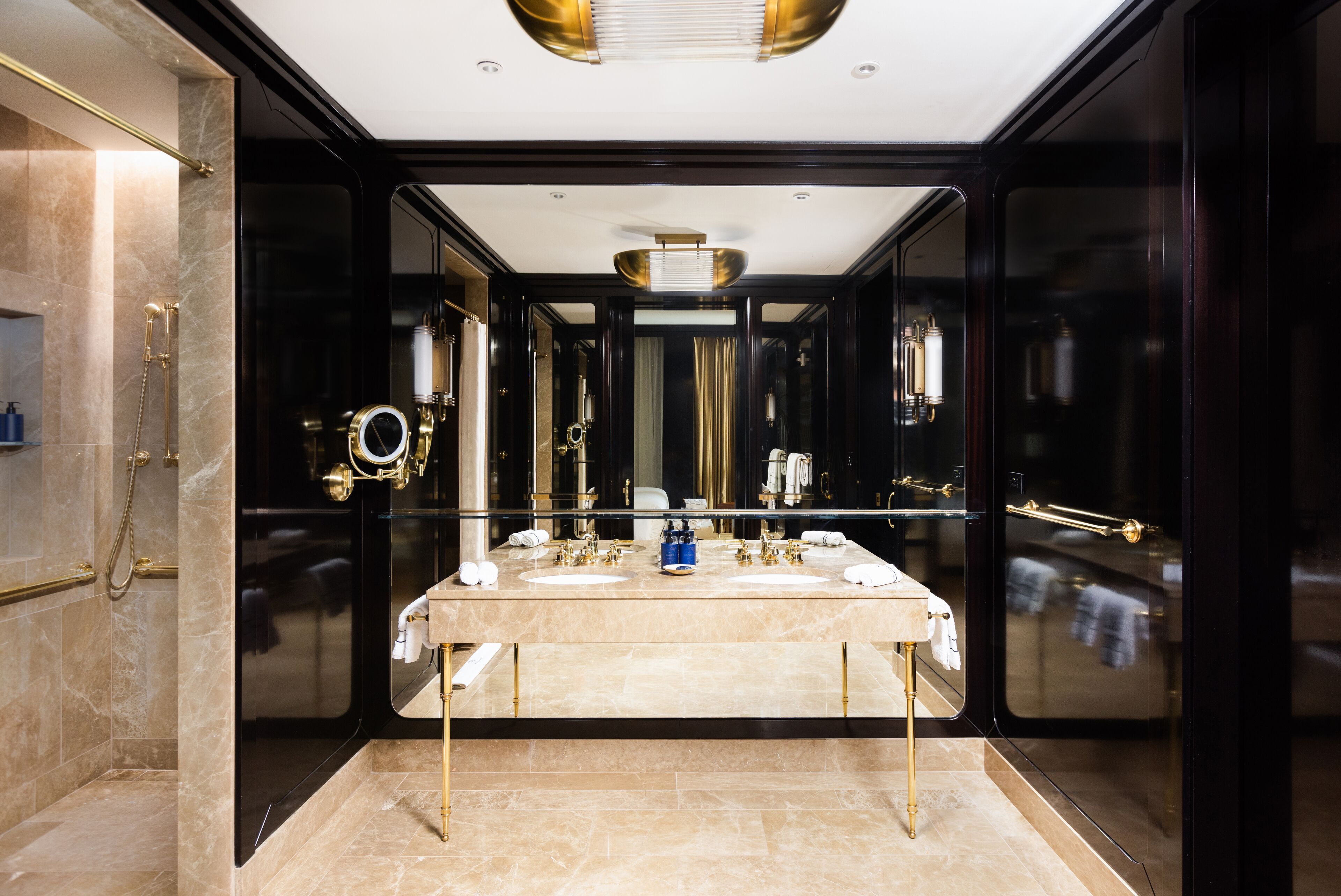 Een luxe badkamer met een grote spiegel, twee wastafels en een opbergruimte.