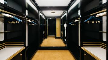 A hotel corridor with mirrored closet doors, a carpeted floor, and a central light fixture.