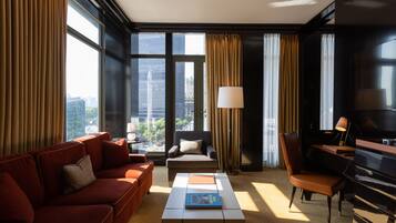 Une chambre d’hôtel moderne avec un canapé, un fauteuil et un piano.