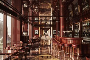 A bar area with high stools, a polished floor, and a view of the bar counter.