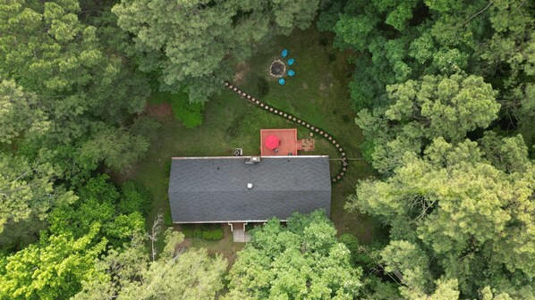 An aerial view of a house surrounded by dense forest. - Modern 4BR 3BA Ranch Home w Fenced-in Backyard (Cary)