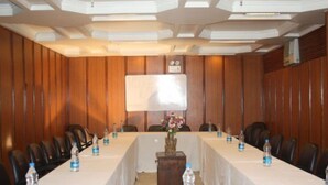 A conference room with a long table, chairs, water bottles, and a whiteboard. - Royal Palace (New Delhi)