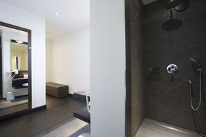 A modern bathroom with a walk-in shower, a vanity with a mirror, and a bench. - Beaumont (Maastricht)