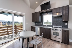 Enjoy meals in this kitchen with a dishwasher, stainless steel range hood, and a large window offering a view of the outdoors.