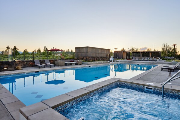 Relax by the serene pool surrounded by lush greenery and comfortable lounge chairs.