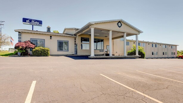 A Buffalo Inn & Suites with a covered front entrance, a parking lot, and a clear sky.