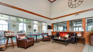 A spacious indoor area with a pool, leather furniture, and large windows.