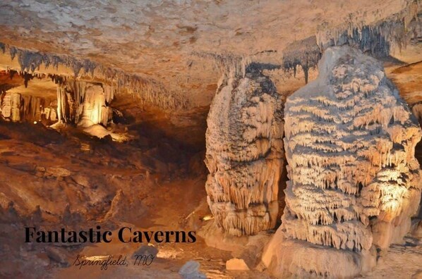 Una cueva con estalactitas y estalagmitas, con la leyenda 'Fantastic Caverns Springfield, MO'.