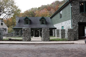 Un edificio de piedra con techo verde y patio amurallado.